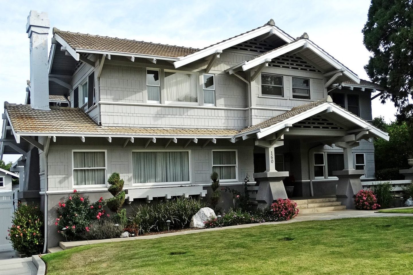A craftsman home photographed in daylight — the photo a crew snaps from the driveway