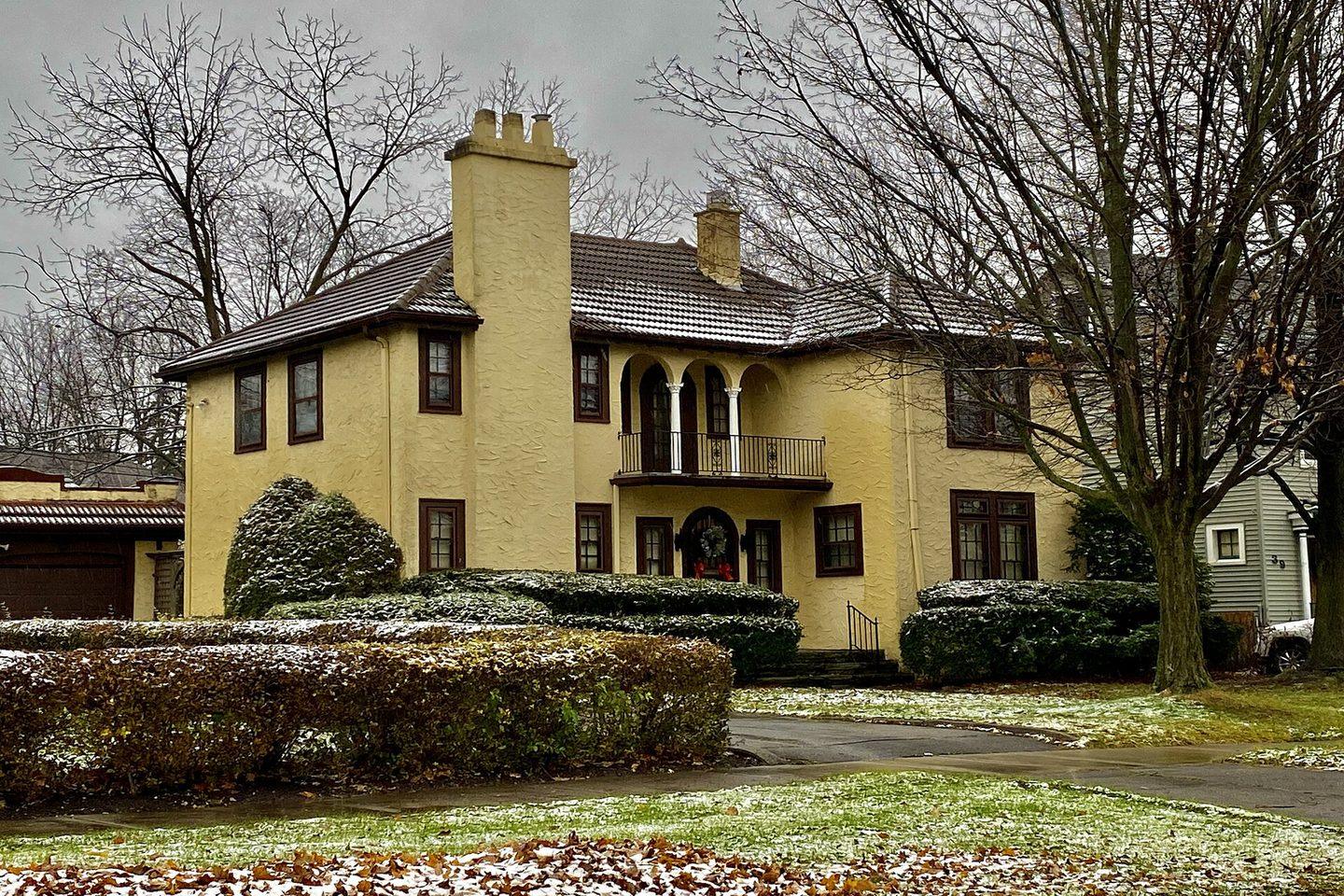 A phone photo of a stucco home on a gray winter afternoon