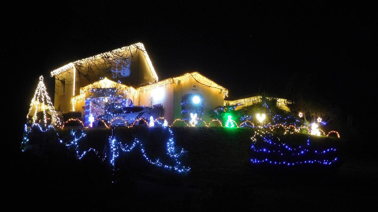 A home glowing with warm Christmas lights against the night